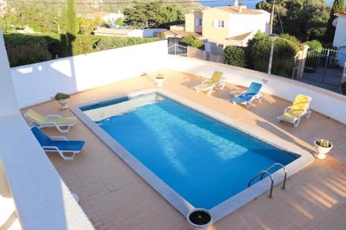 a large swimming pool with chairs and a swimming poolvisor at Luxury Villa with ocean view in Luz