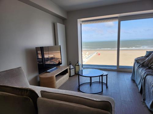 een woonkamer met uitzicht op het strand bij Appart Noah SeaFront in Knokke-Heist