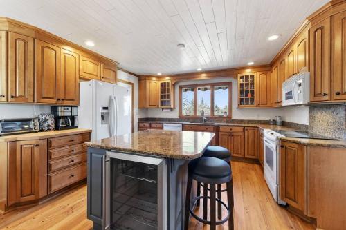een keuken met houten kasten en een eiland met een aanrecht bij Berkshire Beauty-Full Home in Richmond