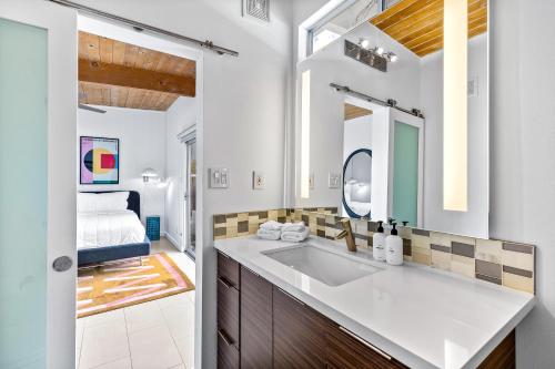 ein Bad mit einem Waschbecken und einem Spiegel in der Unterkunft Mid Century Mood House in Palm Springs