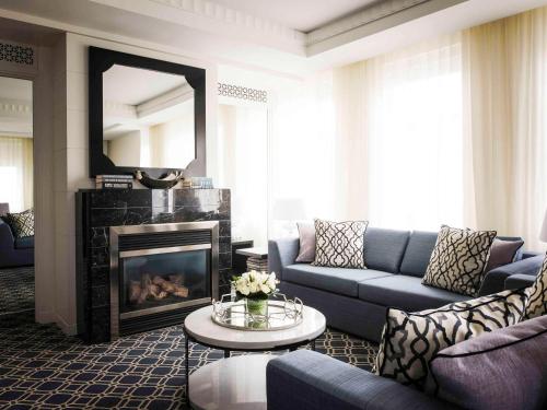 a living room with a couch and a fireplace at Sofitel Lafayette Square Washington DC in Washington