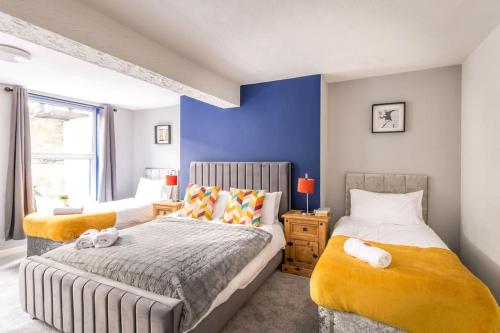 1 dormitorio con 2 camas y pared azul en Contractors, Families, FREE PARKING, Central - Print Place by Prescott Apartments en Bristol