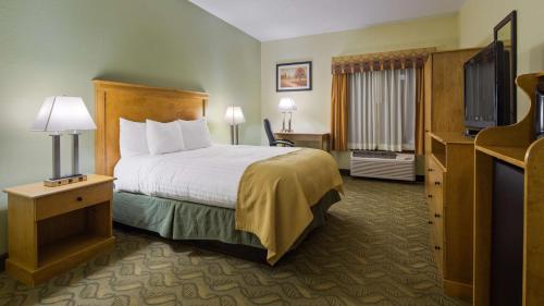 ein Hotelzimmer mit einem Bett und einem Flachbild-TV in der Unterkunft Best Western Crossroads Inn in Schererville