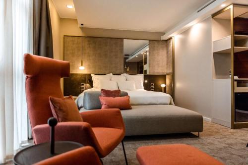 Habitación de hotel con cama y silla en Best Western Premier BHR Treviso Hotel, en Quinto di Treviso