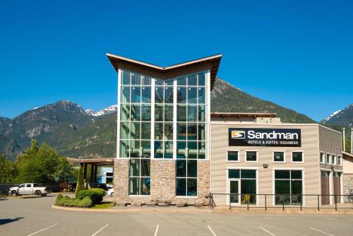 a santander building with mountains in the background at Sandman Hotel and Suites Squamish in Squamish