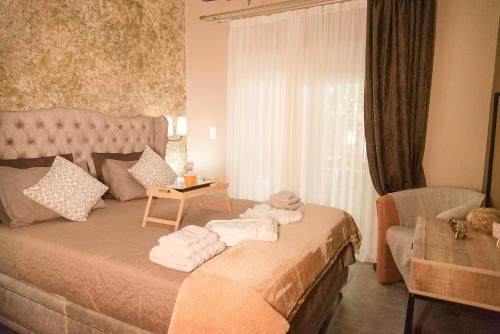 - une chambre avec un lit et des serviettes dans l'établissement The 50/50 Luxury Apartments, à Sidari