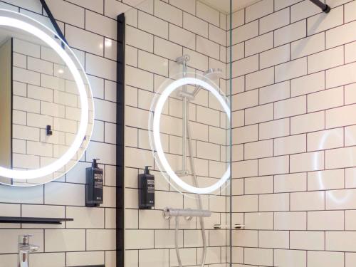 een douche met twee spiegels in de badkamer bij Ibis Lunel Petite Camargue in Lunel