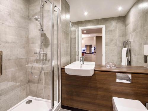 a bathroom with a sink and a shower at Aparthotel Adagio London Sutton Point in Sutton