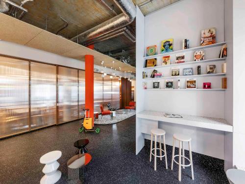 a room with stools and a counter in a building at ibis budget Münster City in Münster