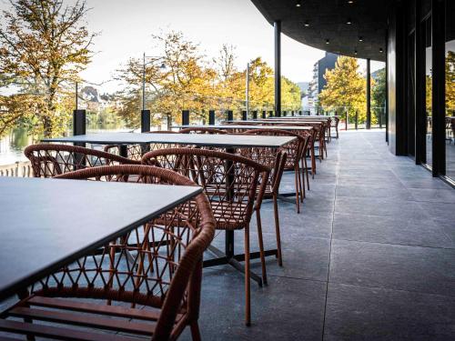 una fila de mesas y sillas en un restaurante en Mercure Namur Hotel en Namur