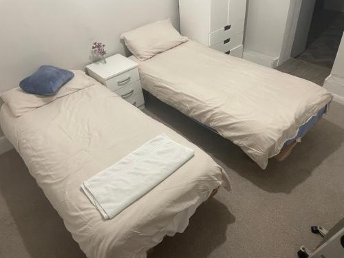 - 2 lits installés l'un à côté de l'autre dans une chambre dans l'établissement Edgware Rooms, à Stone Grove