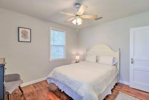 a white bedroom with a bed and a ceiling fan at Pool home sleeps 6 with large fenced yard in Jacksonville