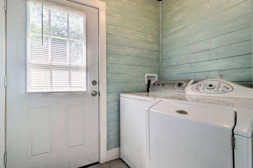 a white washing machine in a laundry room with a door at Pool home sleeps 6 with large fenced yard in Jacksonville