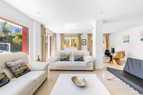 a living room with two white couches and a television at Ohana Luxury Villa with Heated Pool in Málaga