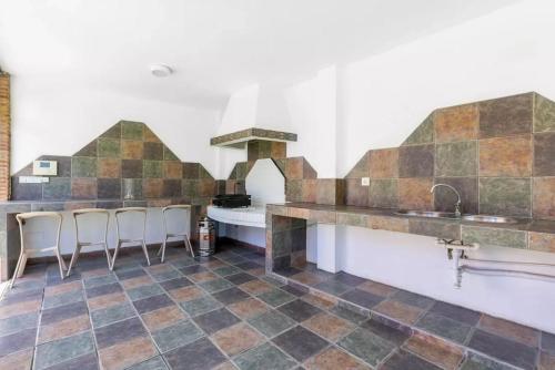 a kitchen with a tile floor and a counter with stools at Ohana Luxury Villa with Heated Pool in Málaga