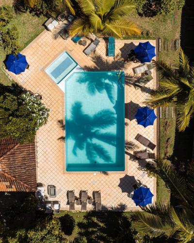 an overhead view of a swimming pool with blue umbrellas at Pousada Estalagem Vila Tania in Itaúnas
