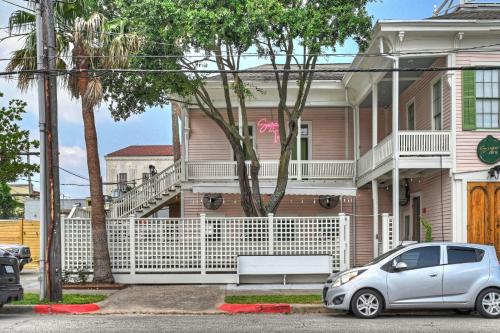 a car parked in front of a pink house at Sugar's INN Room #1 in Galveston