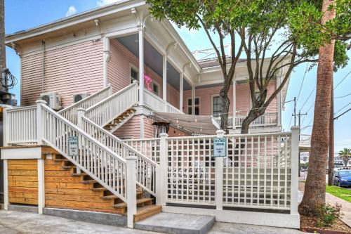 a pink house with a white fence in front of it at Sugar's INN Room #1 in Galveston