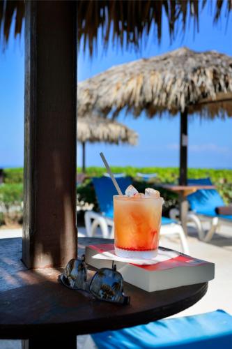 a drink sitting on a table next to an umbrella at Grand Palladium Jamaica Resort & Spa All Inclusive in Lucea