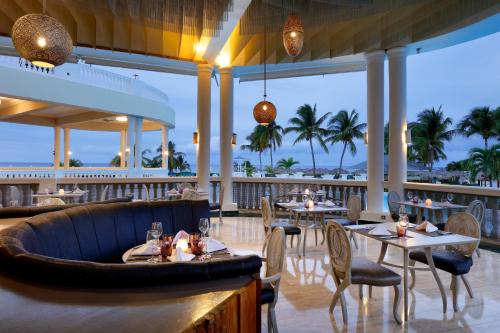 a restaurant on the beach with tables and chairs at Grand Palladium Jamaica Resort & Spa All Inclusive in Lucea