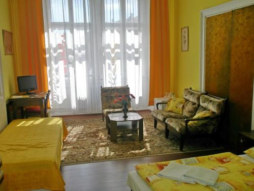 a room with two beds and a couch and a living room at Hotel Morava in Znojmo