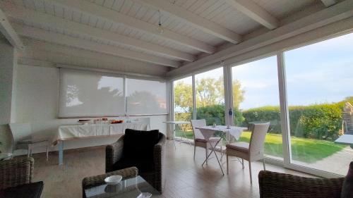 a living room with a table and chairs and windows at A.Mare in Stintino