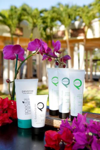 a group of four bottles of spa products on a table with flowers at Grand Palladium Jamaica Resort & Spa All Inclusive in Lucea