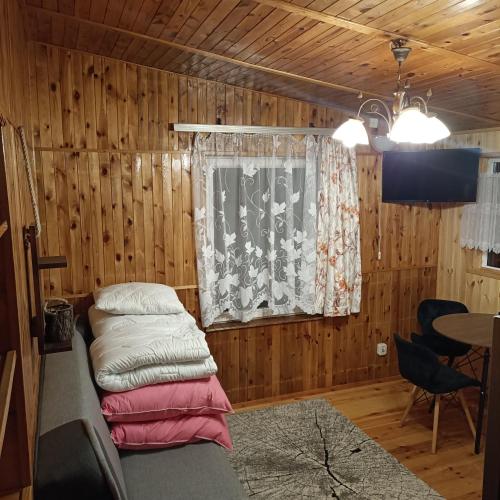 a room with a bed and a window and a table at Domek03 Osrodek Wypoczynkowy Joanna Wojowo in Kargowa