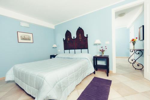 a bedroom with a large white bed and blue walls at Blu Bosa in Bosa
