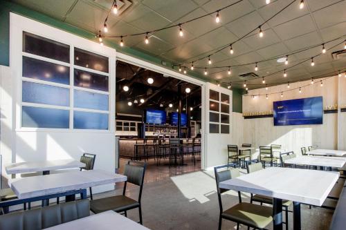 a dining room with tables and chairs and a bar at Four Points by Sheraton Edmonton Gateway in Edmonton