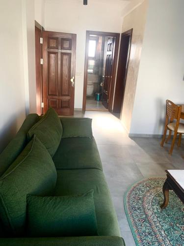 a living room with a green couch and a table at Orya Aparts in Gümbet