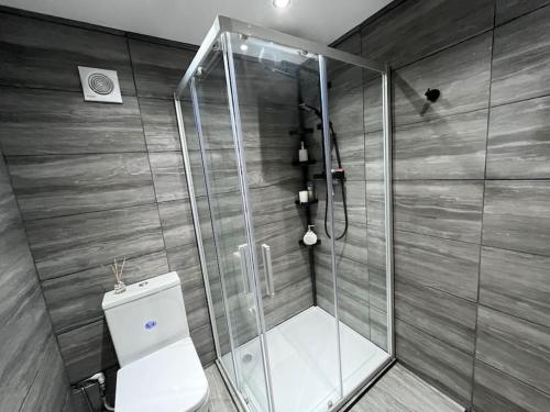 uma casa de banho com um chuveiro e um WC. em Entire Two Bedroom Guest Home Free Parking em Nottingham
