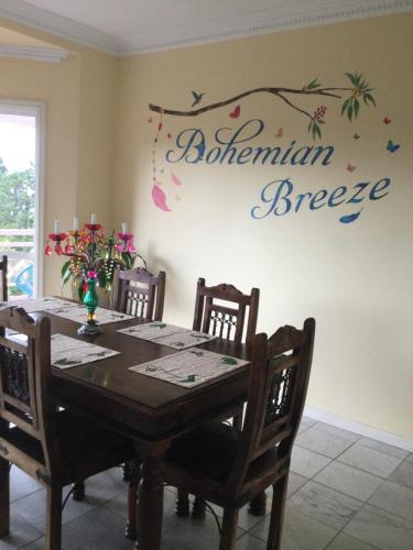 a dining room with a table with a sign on the wall at Bohemian Breeze in Bald Knob