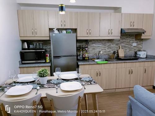 eine Küche mit einem Tisch mit Stühlen und einem Kühlschrank in der Unterkunft Spacious 1 BR condo unit Near NAIA in Manila
