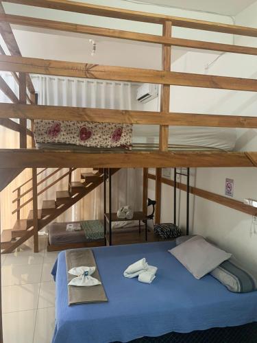 a room with a bunk bed with blue sheets and towels at Aconchego do Vale in Blumenau