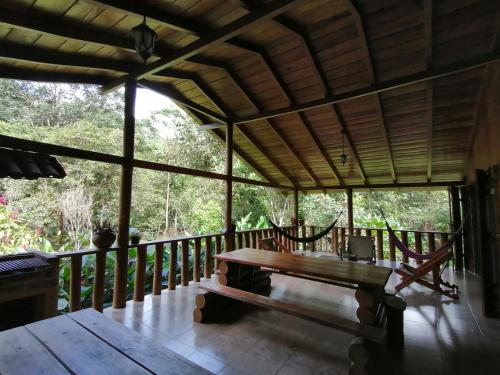 una veranda di una casa con tavolo in legno di La Chonta a Mindo