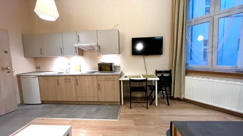 Spacious Studio في كراكوف: مطبخ مع طاولة وتلفزيون في الغرفة