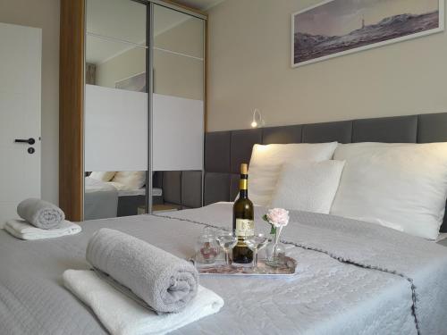 a bedroom with a bed with a bottle of wine and towels at Arte Porta Mare in Kołobrzeg