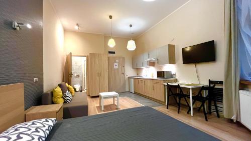 une chambre avec un lit et une cuisine et une chambre avec dans l'établissement Spacious Studio, à Cracovie