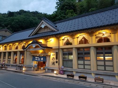 a building with benches on the side of the street at Tsukimotoya Ryokan in Toyooka