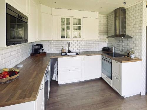 a kitchen with white cabinets and a wooden floor at 6 person holiday home in TINGSRYD-By Traum in Tingsryd