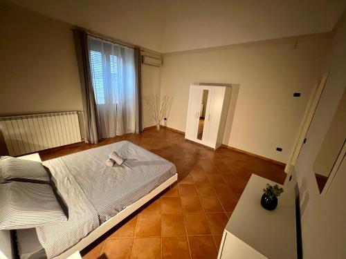 een slaapkamer met een wit bed en een groot raam bij La Pietra Messapica in Manduria