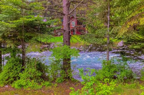a painting of a house in the woods with blue flowers at Wallowa Lake Wonder in Joseph
