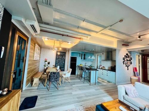 Our cozy and exclusive 2BR at Kemang Village في جاكرتا: غرفة معيشة مع مطبخ وغرفة طعام