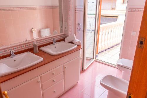 a bathroom with two sinks and a large mirror at Casa Valentina in Jávea