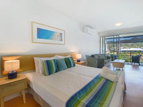 a bedroom with a large bed and a living room at Blue on Blue Studio Room 1222 in Nelly Bay
