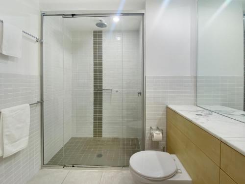 a bathroom with a shower with a toilet and a sink at Blue on Blue Studio Room 1222 in Nelly Bay