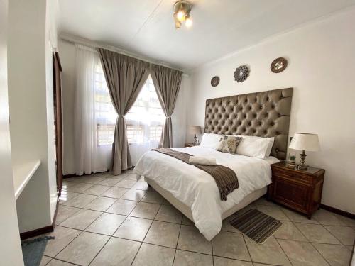 a bedroom with a large bed and a large window at Siena Sun Apartment 4 in Midrand