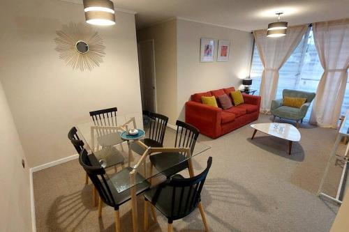 a living room with a glass table and a couch at Condominio privado. Cómodo y central departamento nuevo in Talca