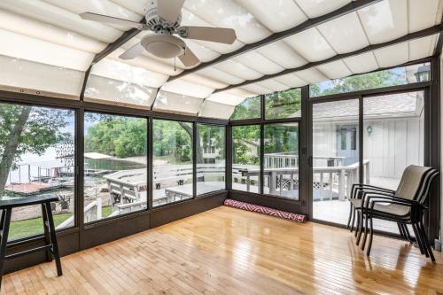 an open living room with a ceiling fan and large windows at Unforgettable Lake Memories in Lake Ozark